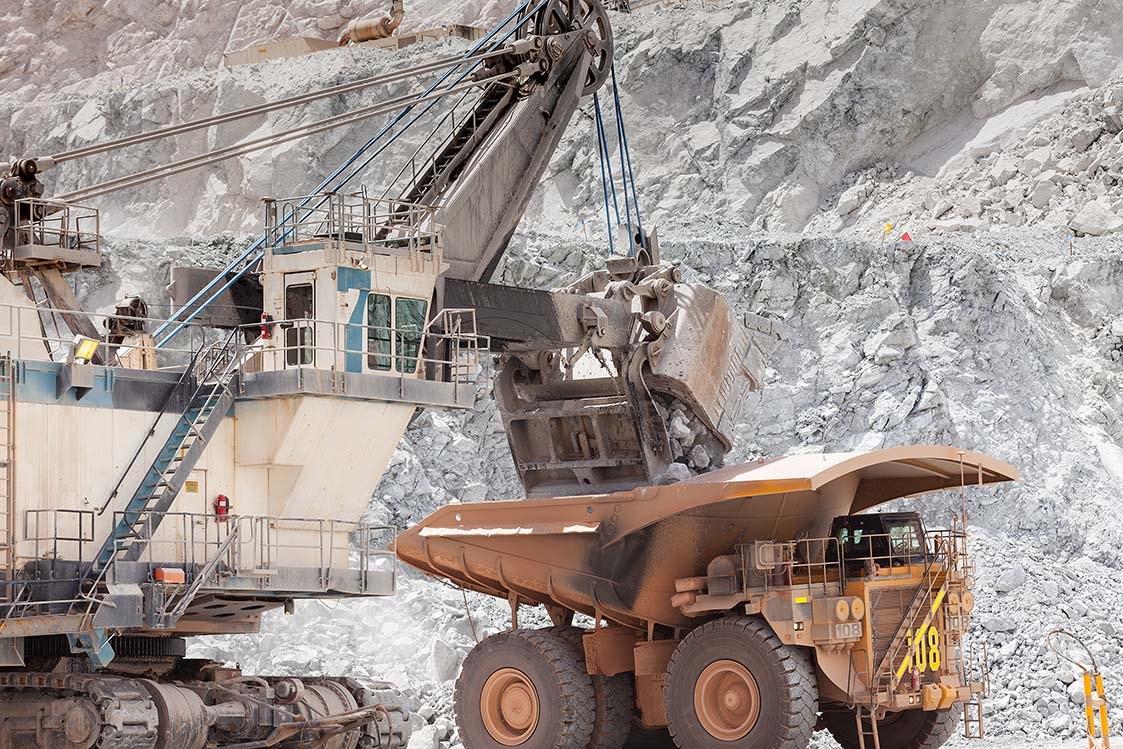 Electric rope shovel loading a dump truck in an open pit mine