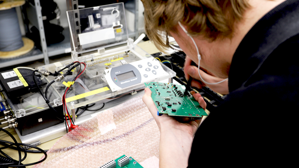 Electronics technician soldering on a circuit board